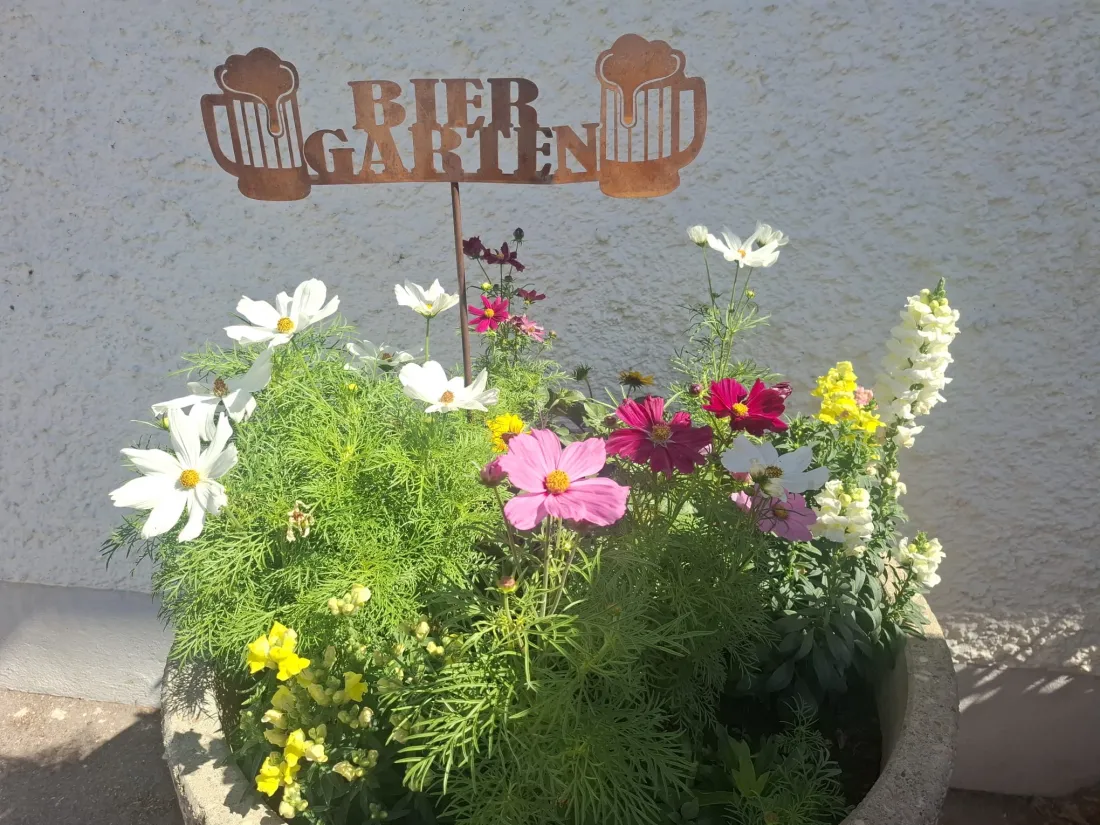 Blumengesteck mit Biergarten-Schild