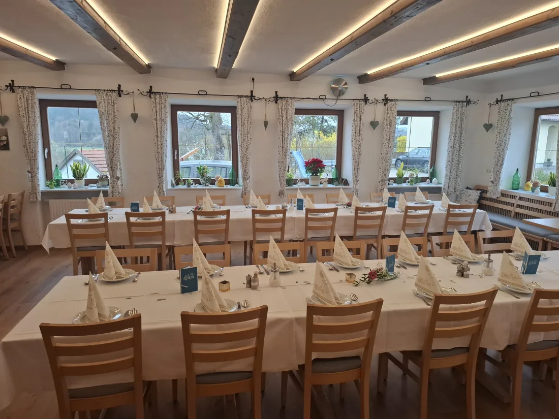 Heller Saal im Wirtshaus zur Sonne mit festlich eingedeckten Tafeln und Blick ins Grüne
